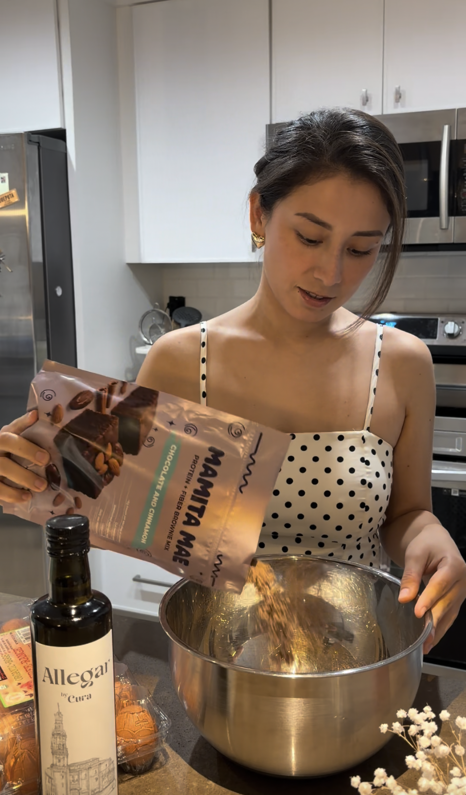 Woman pouring Mamita Mae brownie mix into a mixing bowl