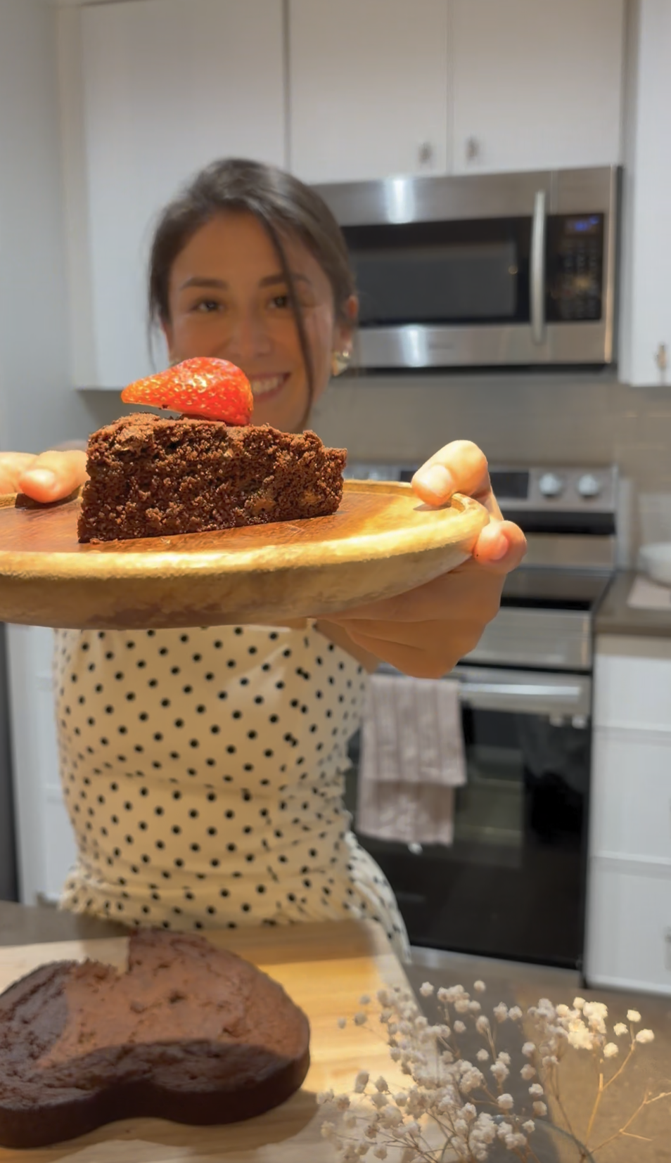 Serving a slice of Mamita Mae brownie on a wooden board with strawberry